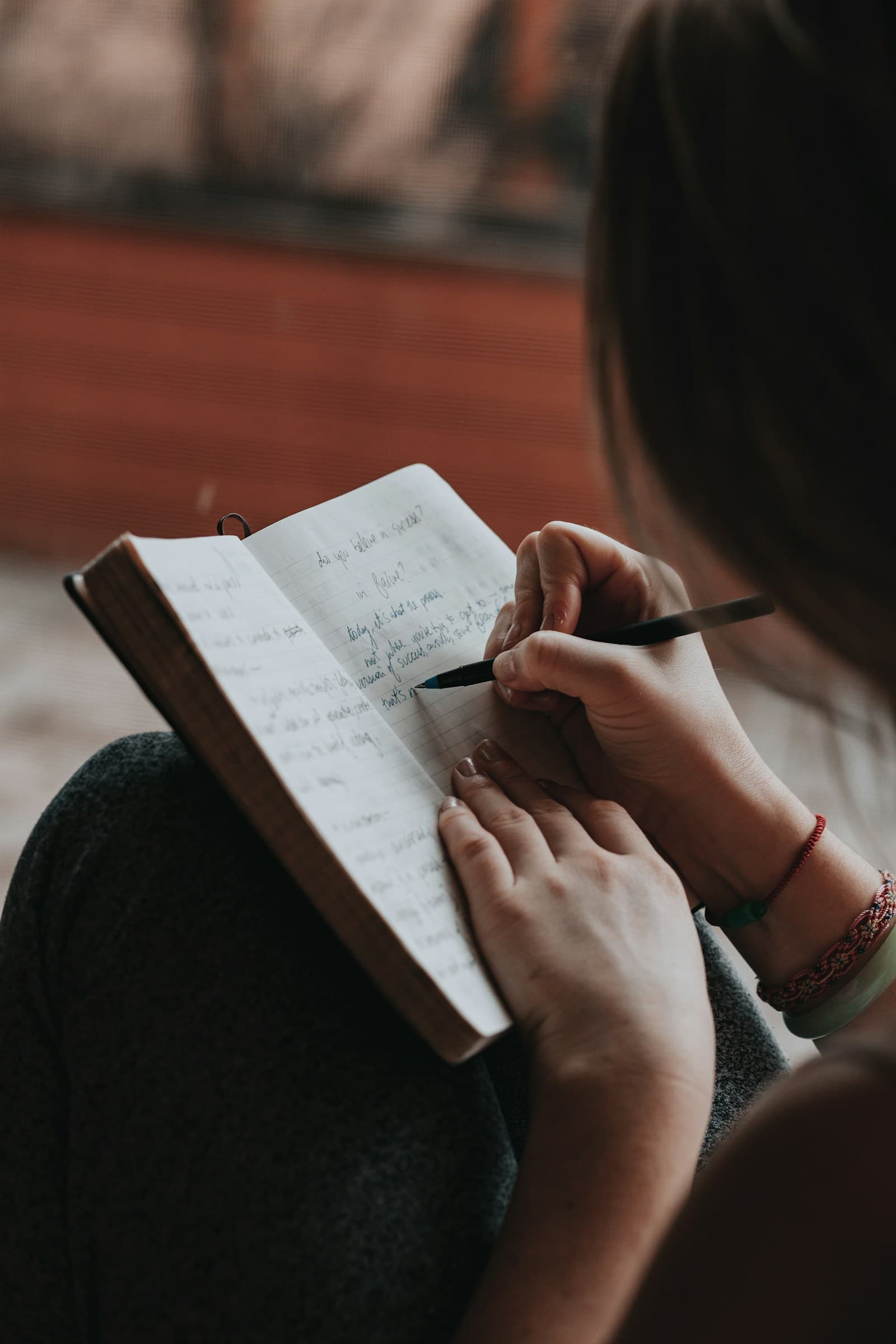ノートにペンで書き込む女性